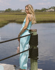 Woman in a light blue matching set by a body of water