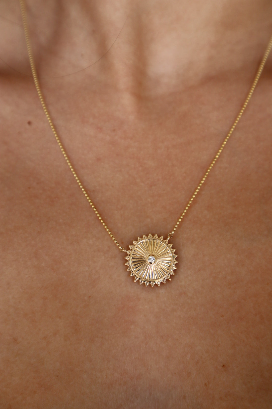 Mandala Medallion Necklace extreme close up showing gold side on model's neck