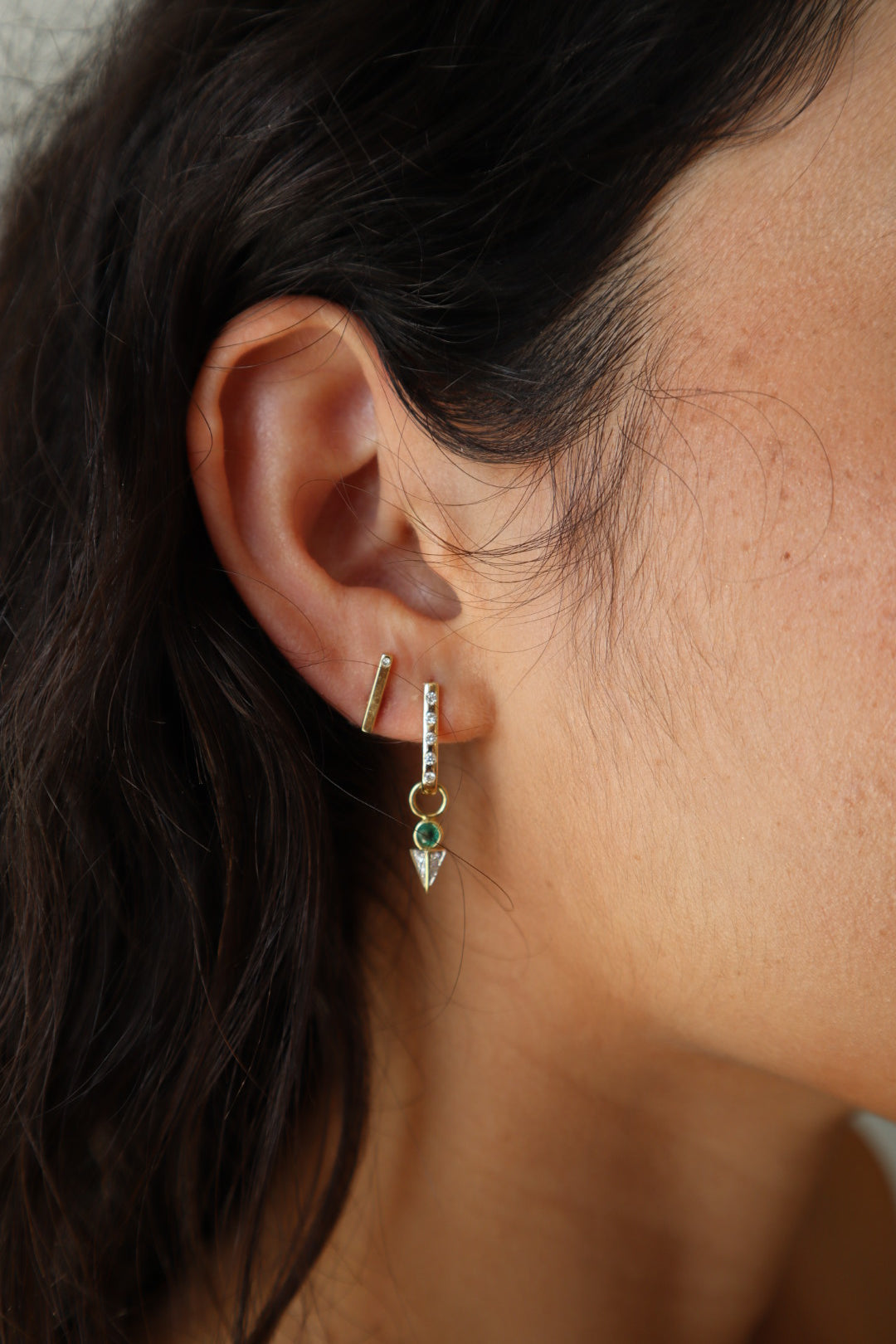 Single Tiny Emerald Pyramid Charm extreme close up side view on model