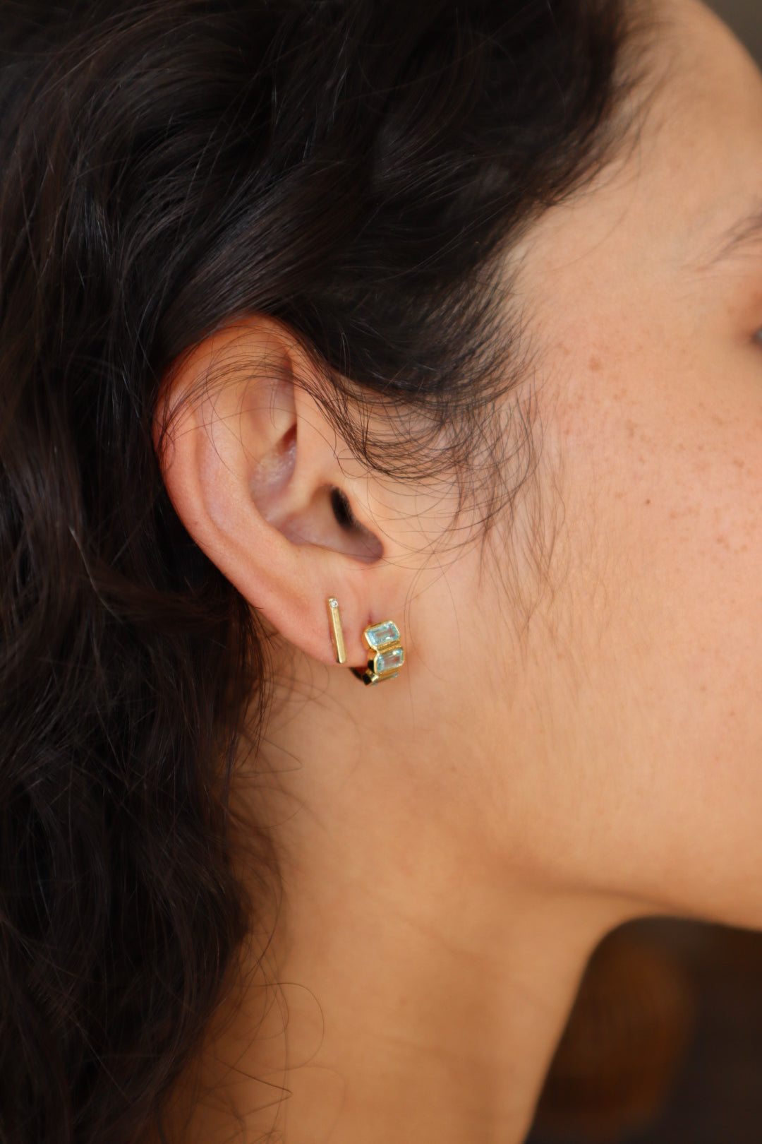 Sunset Huggie Hoops in Aqua close up side and partial back view