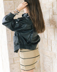 Early oversized faux leather coat on a model with a mini dress side view