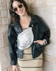 Early oversized faux leather coat on a model with a silver bag and mini dress wearing sunglasses, front