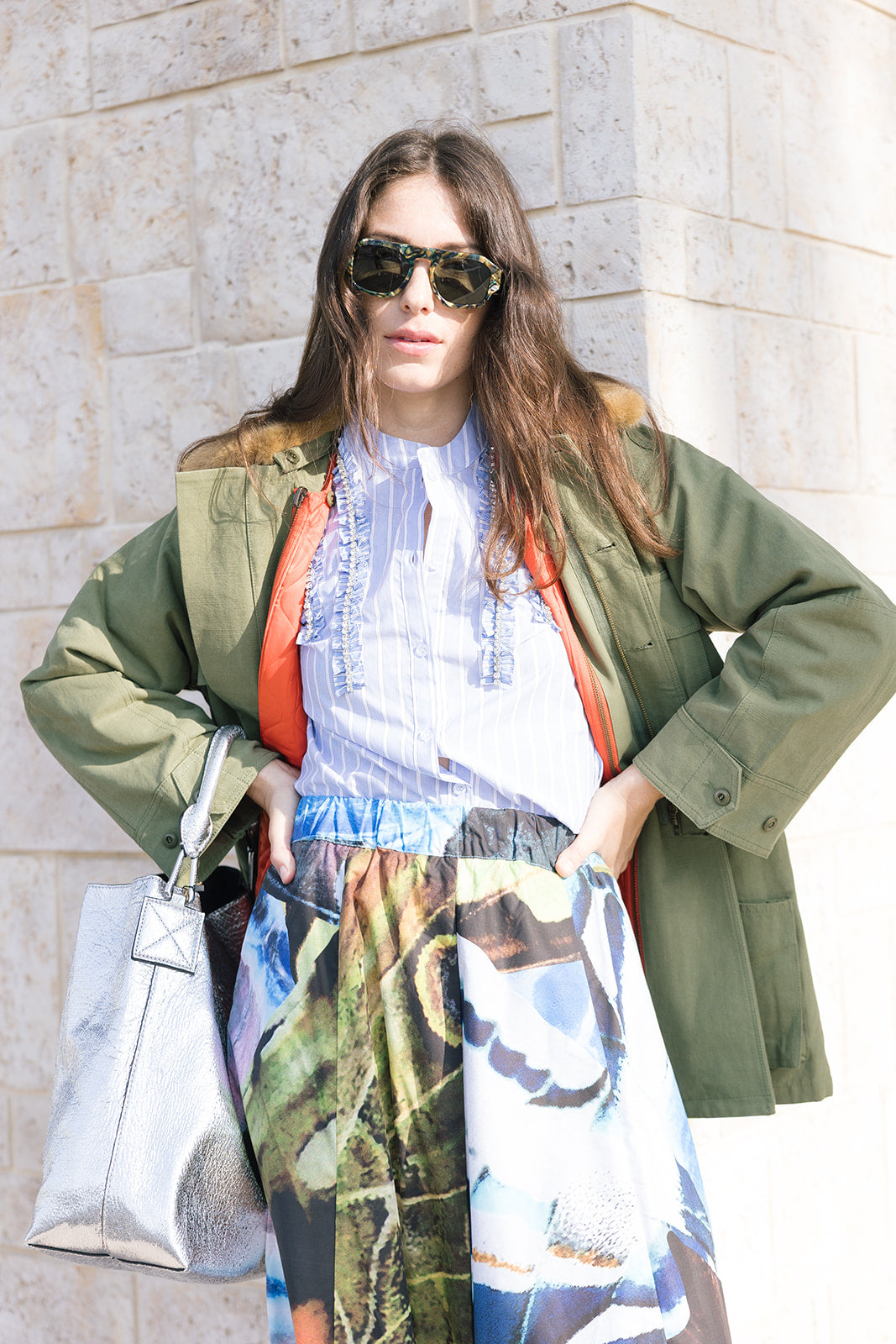 The Quilted Liner Parka open on model with stripe button down and print skirt and silver bag