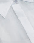Close-up of a blue sheer shirt with a collar and button on a light gray background