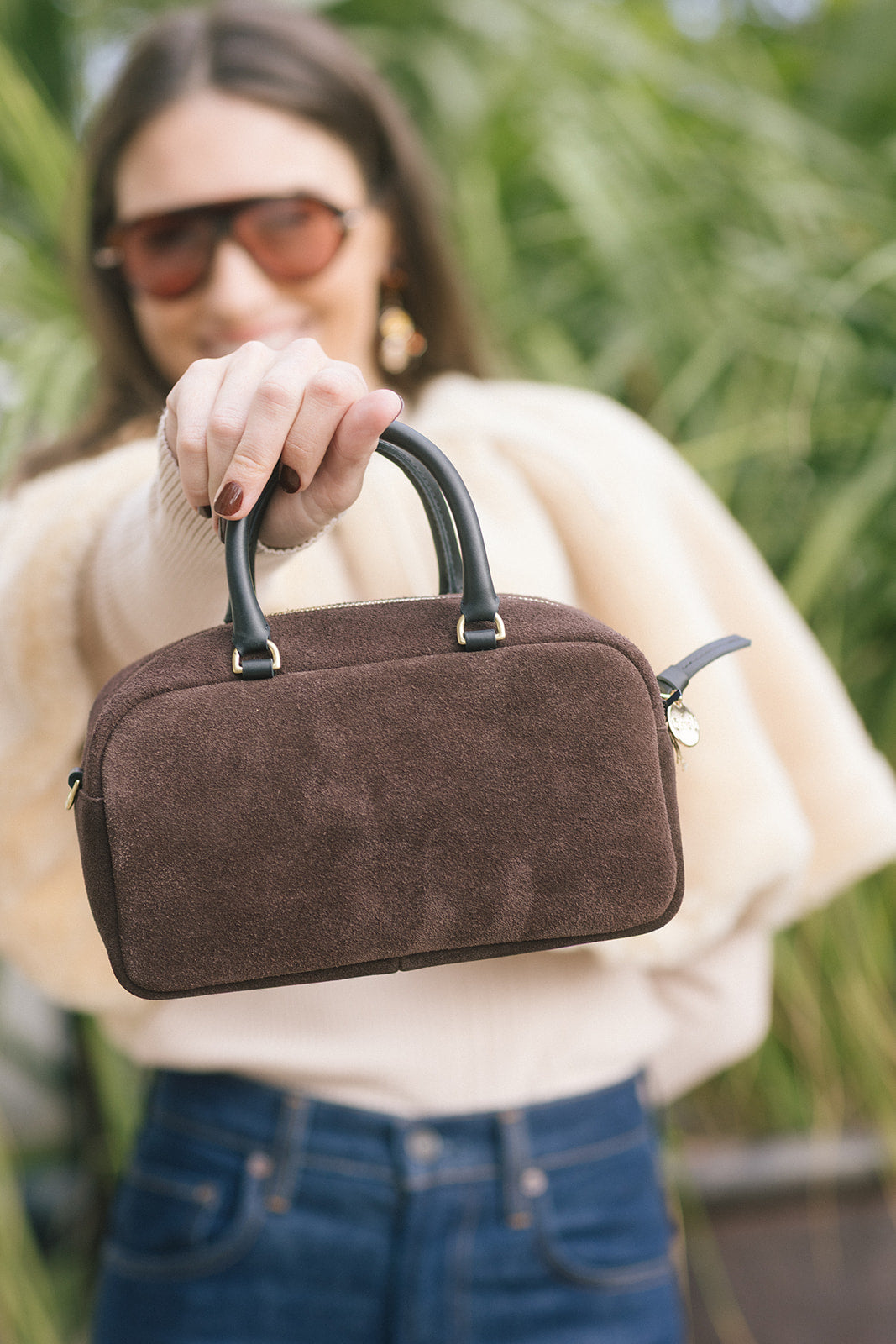 model holding a small rectangle suede brown bag 