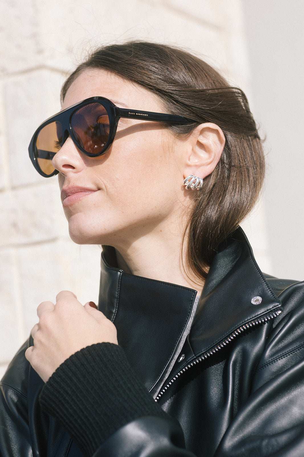 model wearing oversized black sunglasses with a black jacket 