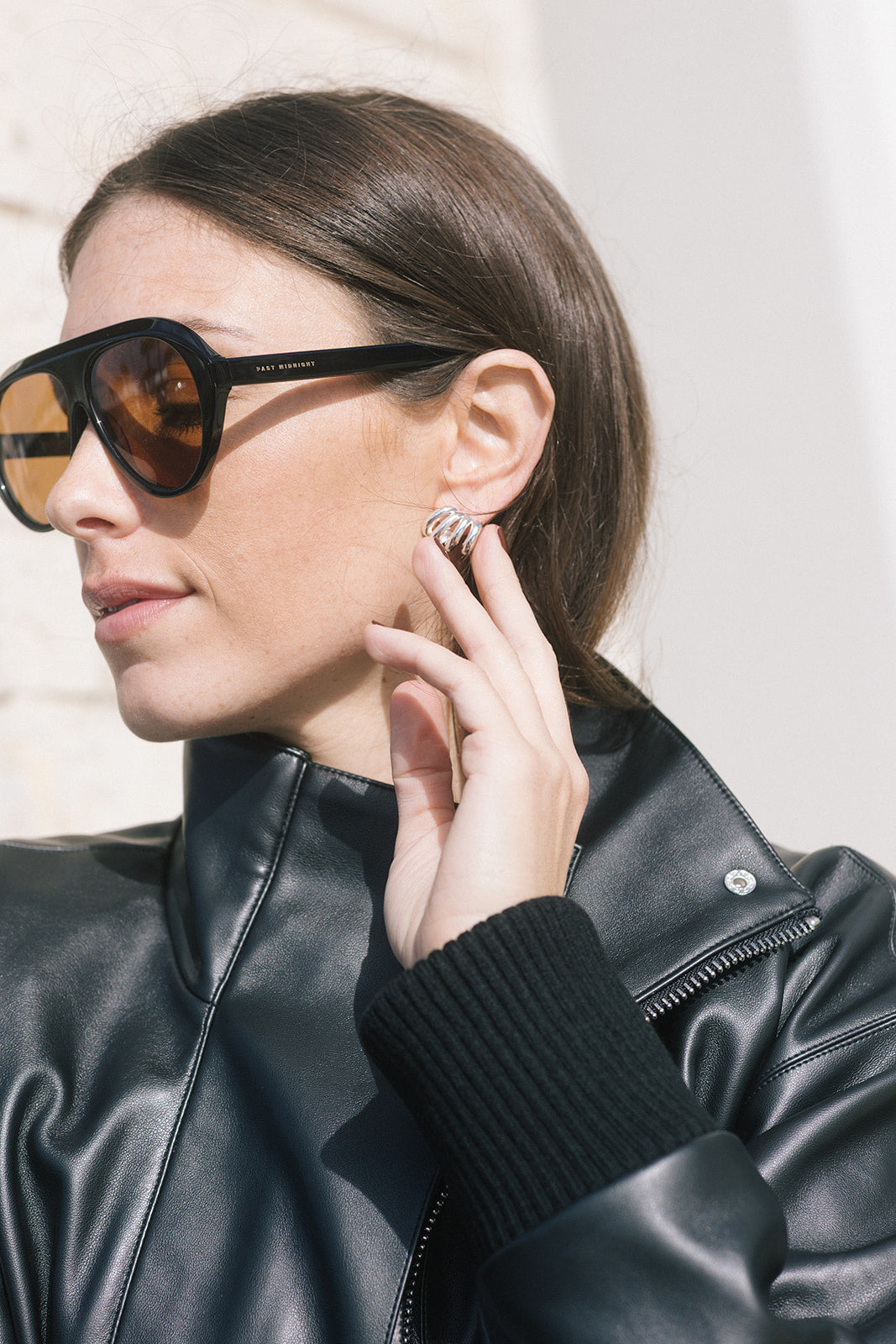 model wearing oversized black sunglasses with a black jacket 