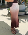 A woman stands outdoors on a patio wearing a sleeveless ombre maxi skirt 