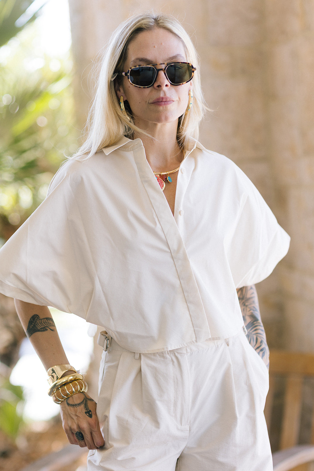 Person wearing a cream outfit with Jordan Sunglasses Nikko Tortoise + 12K Polarized in an outdoor setting