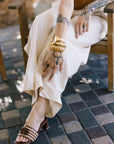 Person wearing Sydney Rope Woven Block Heel and bracelets on a tiled floor
