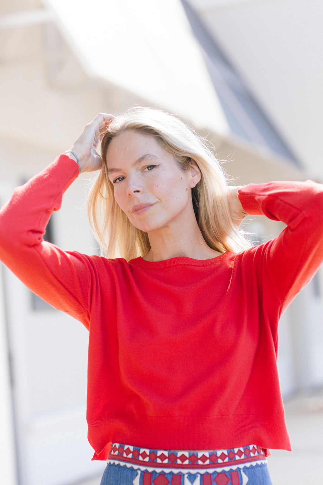 Polly Sweater Red front, model's arms up