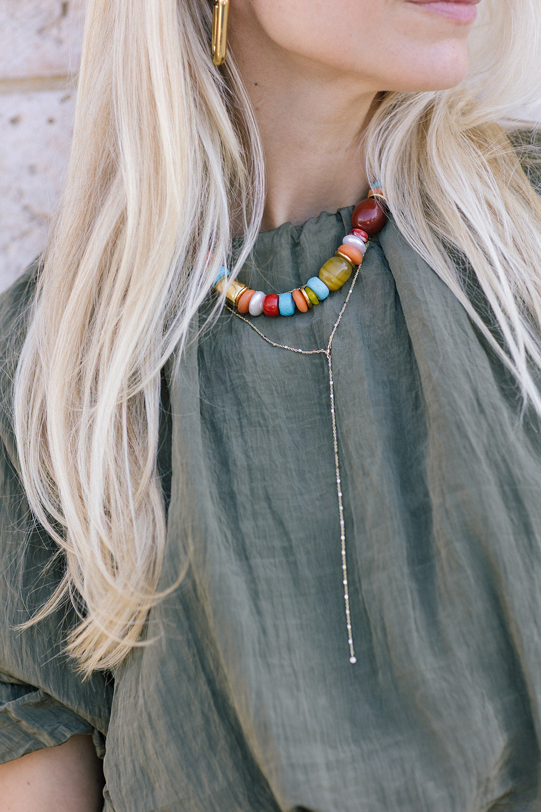 Close-up of a person wearing a colorful beaded necklace and Ace Lariat