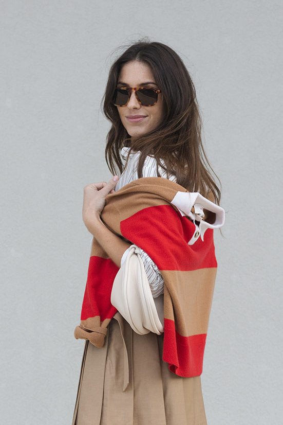 Woman holding Braxton Rugby Stripe Sweater against a plain background
