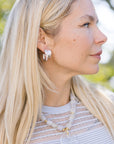 Close-up of a woman wearing Leona Hoops Silver and a necklace with a blurred natural background