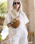 Woman in a white outfit holding Petite Fanny Tan Rattan