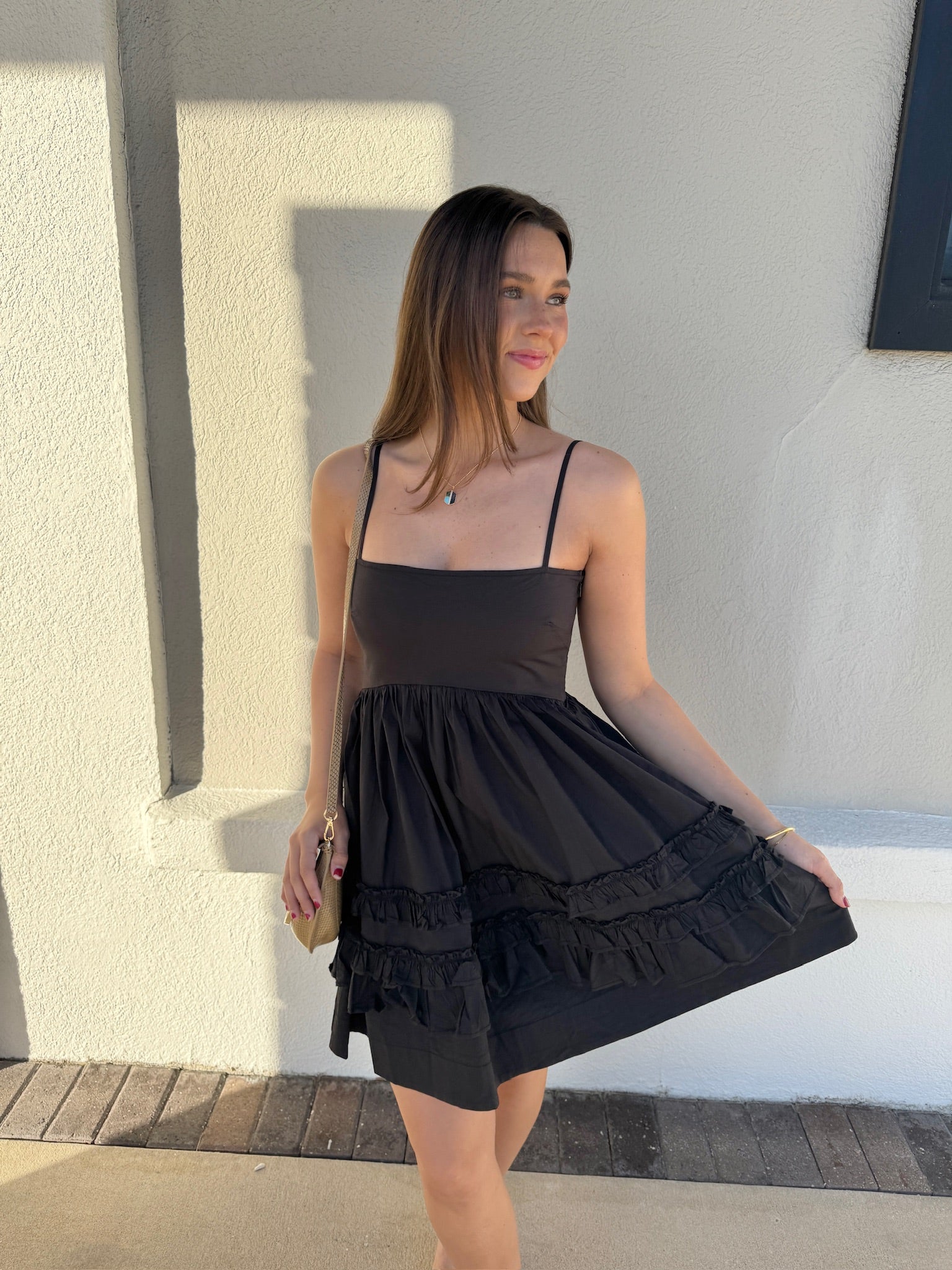 Mini Strap Dress with Frills front view, model holding out skirt