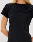 Black ruffled blouse worn by a person on a white background front view 