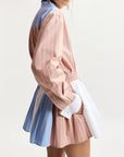 Person wearing a pink and blue striped outfit on a light background