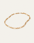 Gold chain bracelet on a light beige background