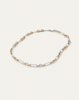 Two-tone gold and silver chain necklace on a light beige background