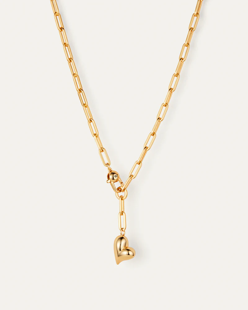 Gold chain necklace with a heart pendant on a white background