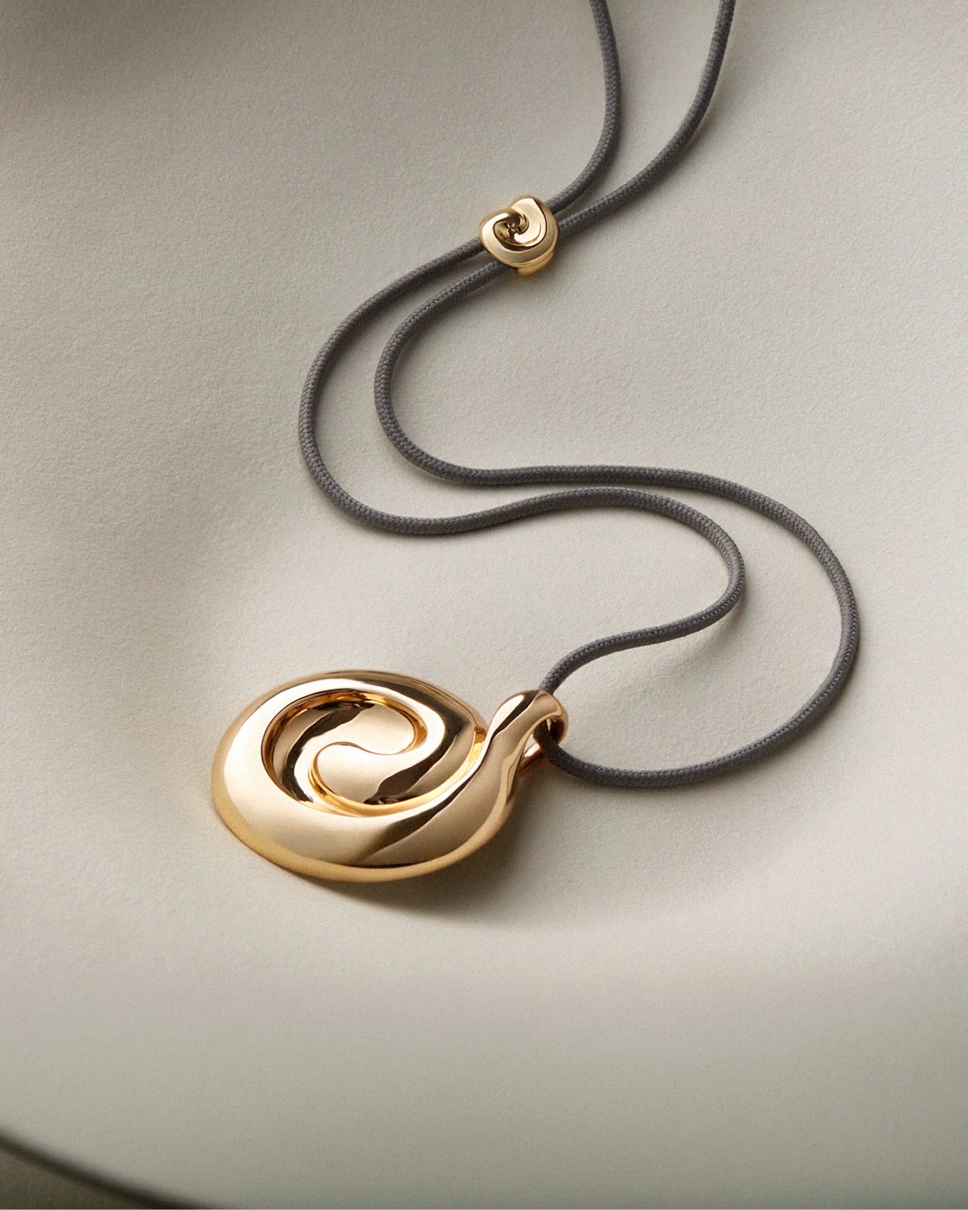 nico mirror pendant necklace flat on a cream background