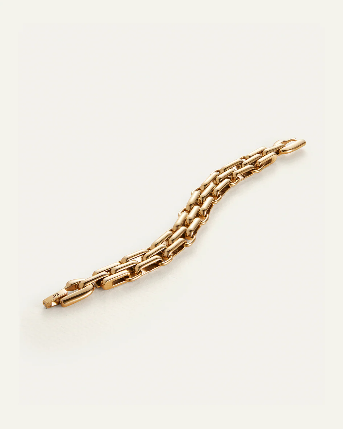 Gold chain bracelet on a light beige background