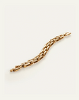 Gold chain bracelet on a light beige background