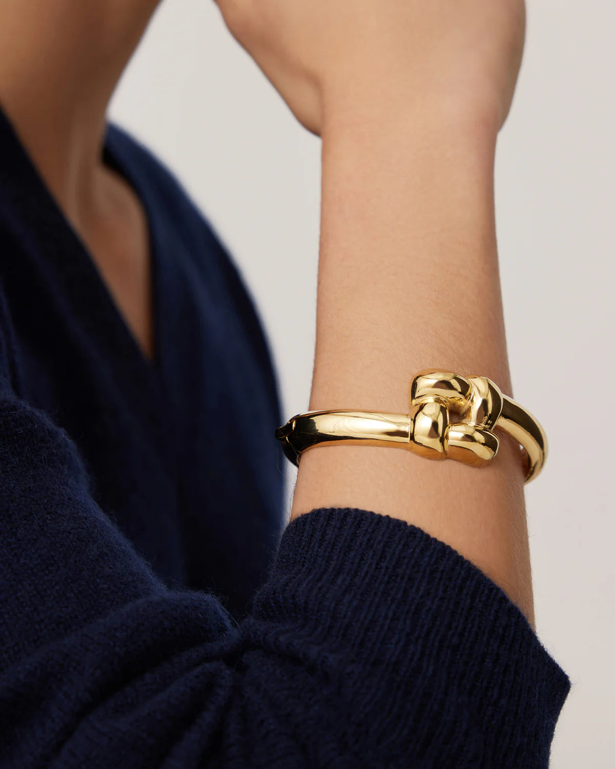 Gold bracelet on a person's wrist with a blurred background