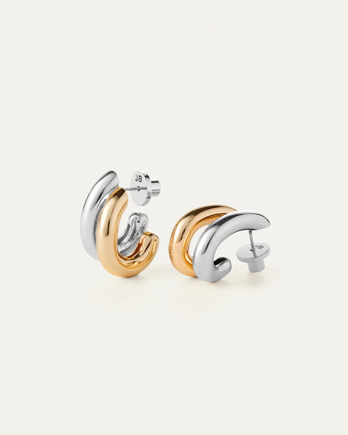 Pair of gold and silver hoop earrings on a white background