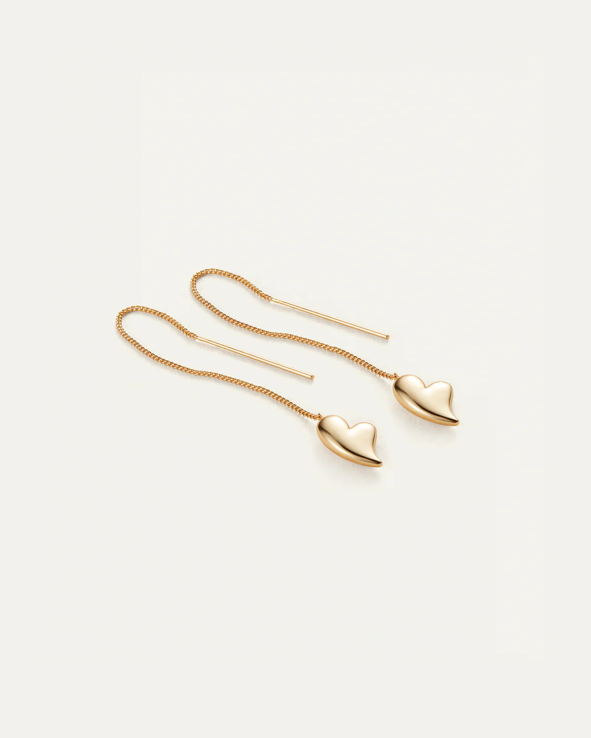 Gold heart-shaped earrings on a white background