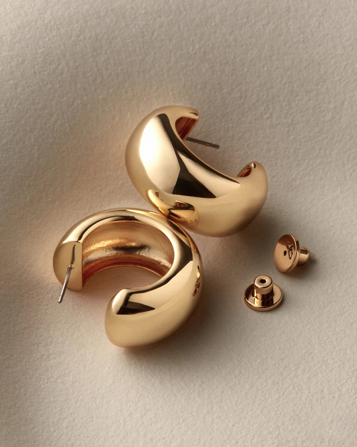 chunky gold hoops on a white background