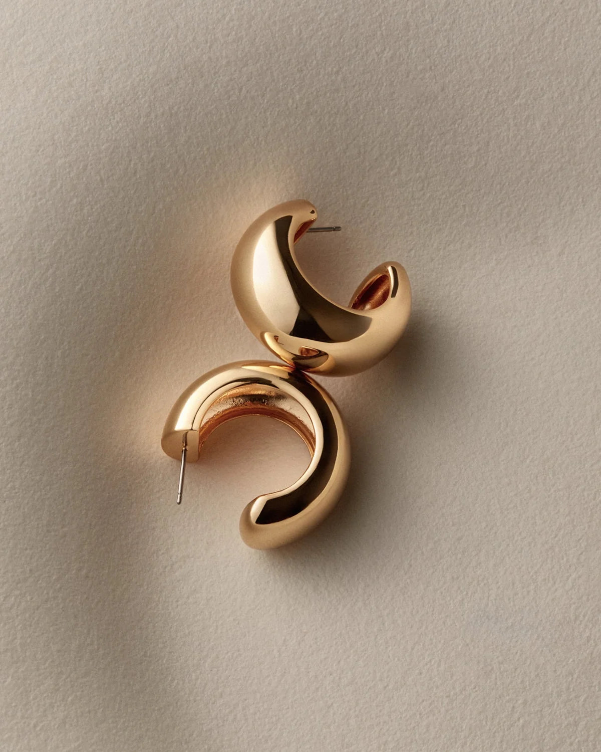 chunky gold hoops on a white background
