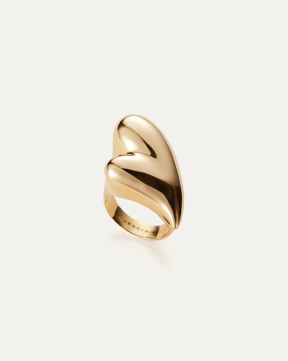 Gold ring with a wavy design on a light beige background