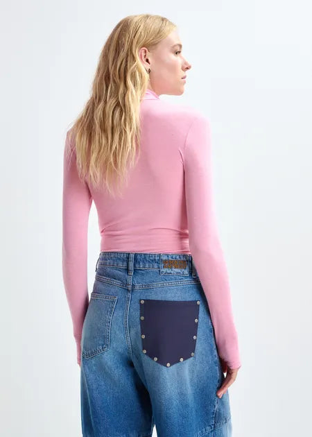 Person wearing a pink top and blue jeans with a patch on a white background