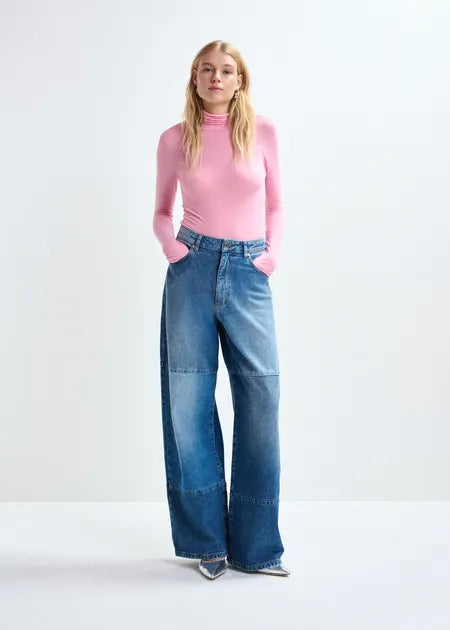 Person wearing a pink sweater and blue jeans on a white background