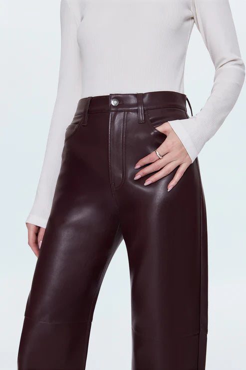 Brown leather pants worn by a person on a light gray background front view