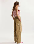 Woman wearing a floral top and beige pants on a white background