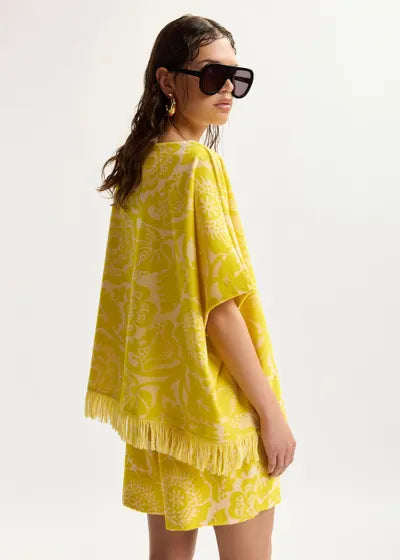 Woman wearing a yellow matching set with sunglasses on a white background