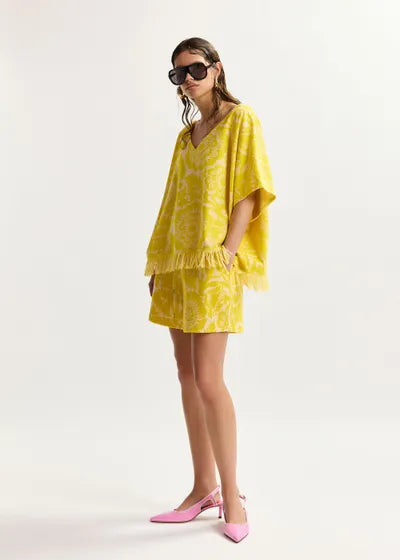 Woman wearing a yellow matching set with a white background