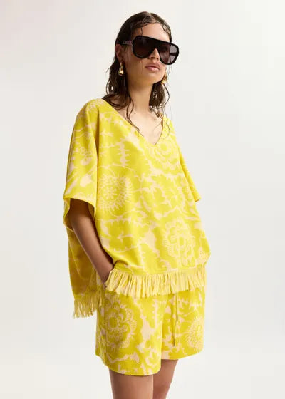 Woman wearing a yellow matching set with sunglasses on a white background