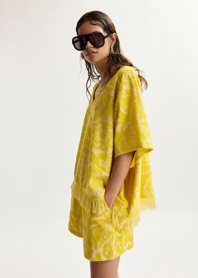 Woman wearing a yellow matching set with a white background