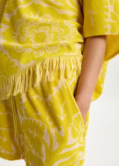 Yellow set with floral pattern and fringes on a white background