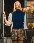 model wearing floral shorts and navy blue sweater vest
