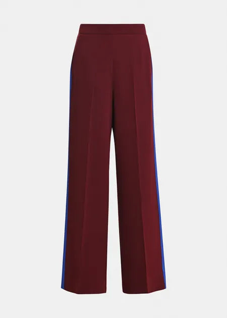 A pair of high-waisted, wide-leg trousers in deep burgundy with vibrant blue side stripes, shown against a plain light gray background.