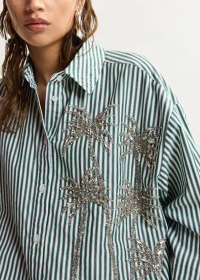 Striped shirt with palm tree designs and sequins on a plain background