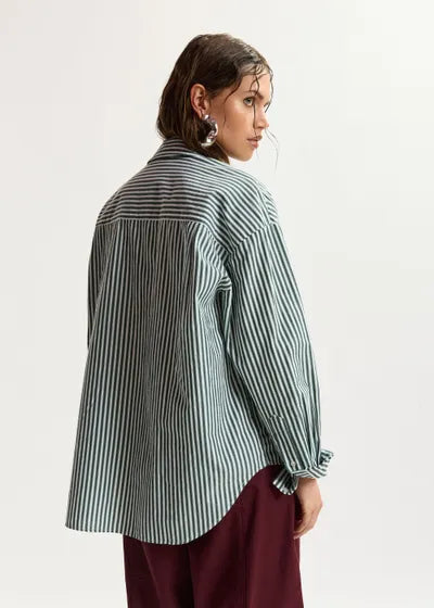 Person wearing a striped shirt and burgundy pants on a white background