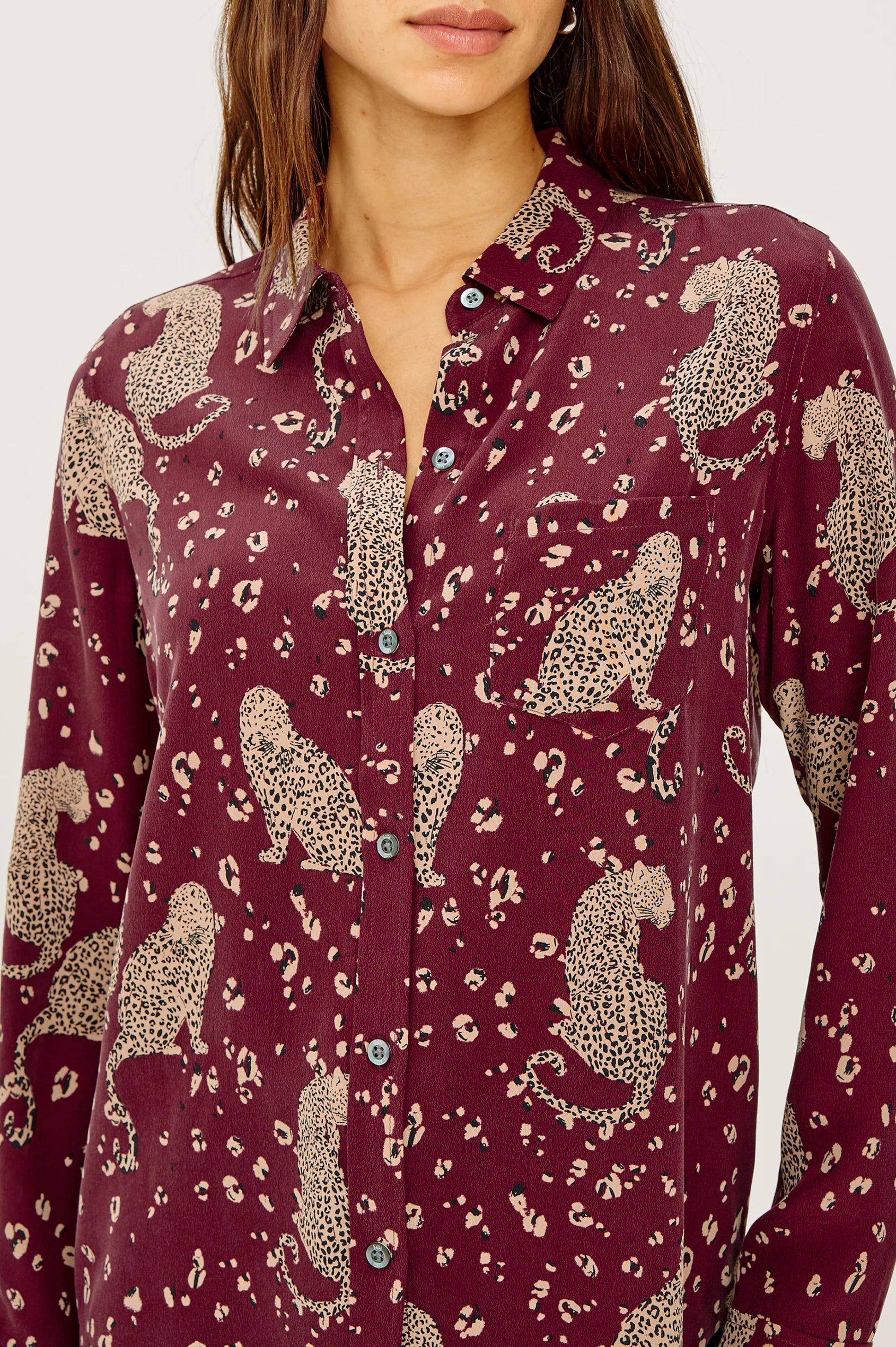 Maroon shirt with animal print worn by a person against a white background
