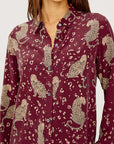 Maroon shirt with animal print worn by a person against a white background