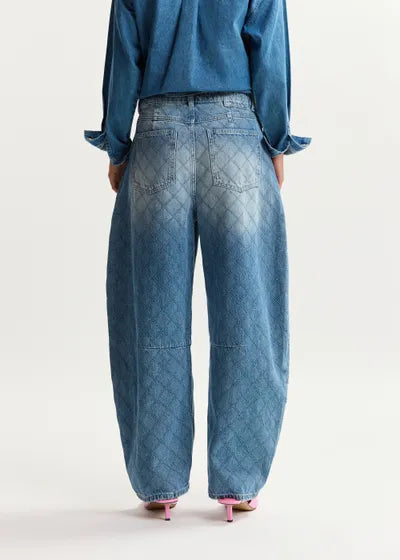 Person wearing blue jeans and a matching top on a white background